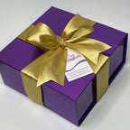Purple gift box with a gold bow on a white background