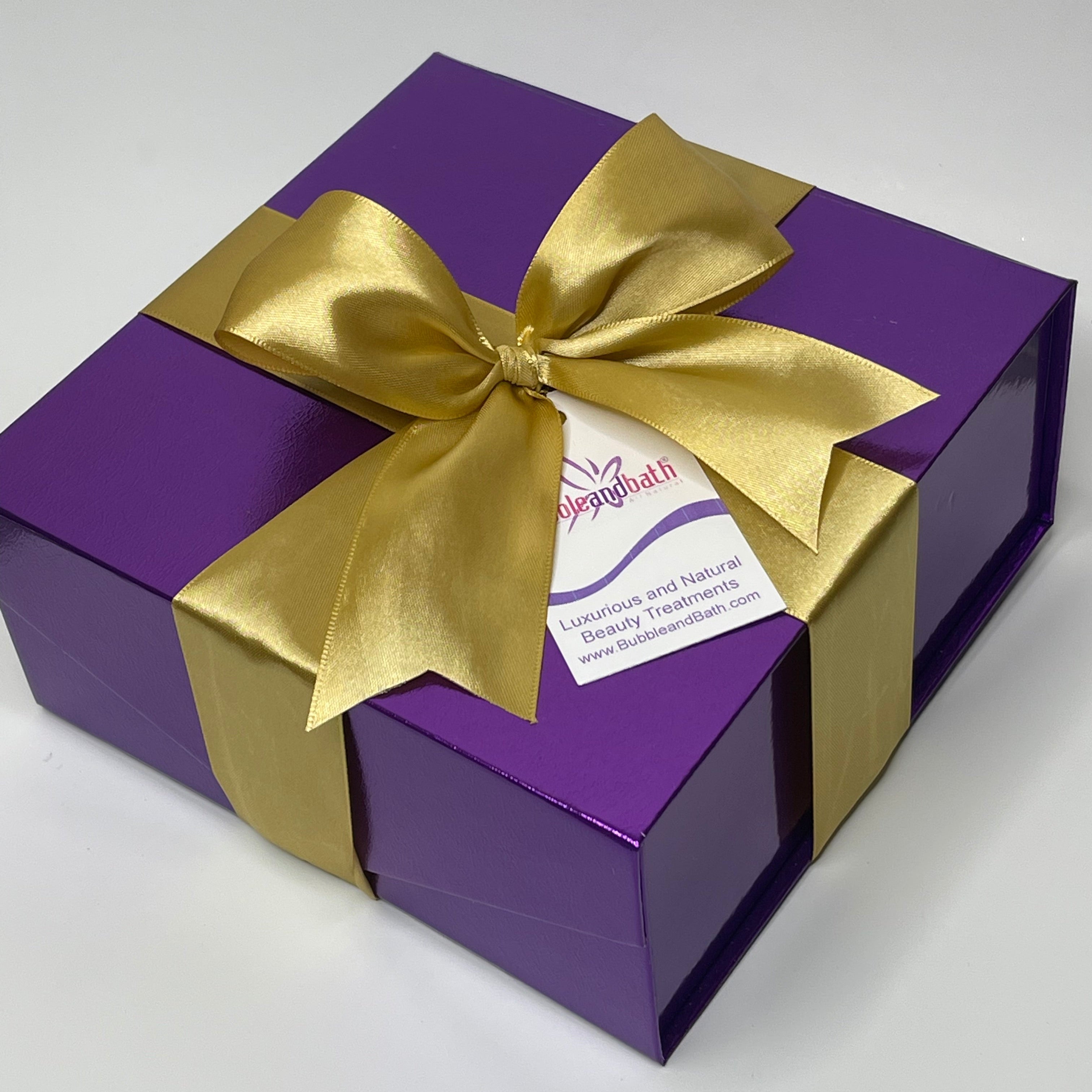 Purple gift box with a gold bow on a white background